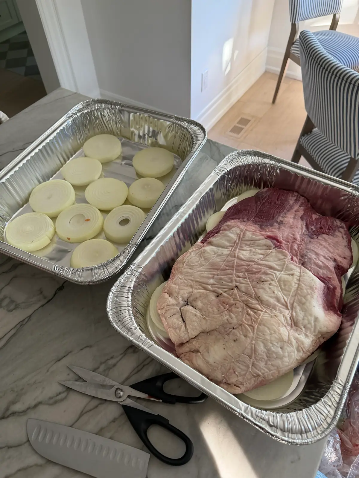 Steps 1 and 2. Sliced onions lining the pans, with a brisket on the onions fat side up