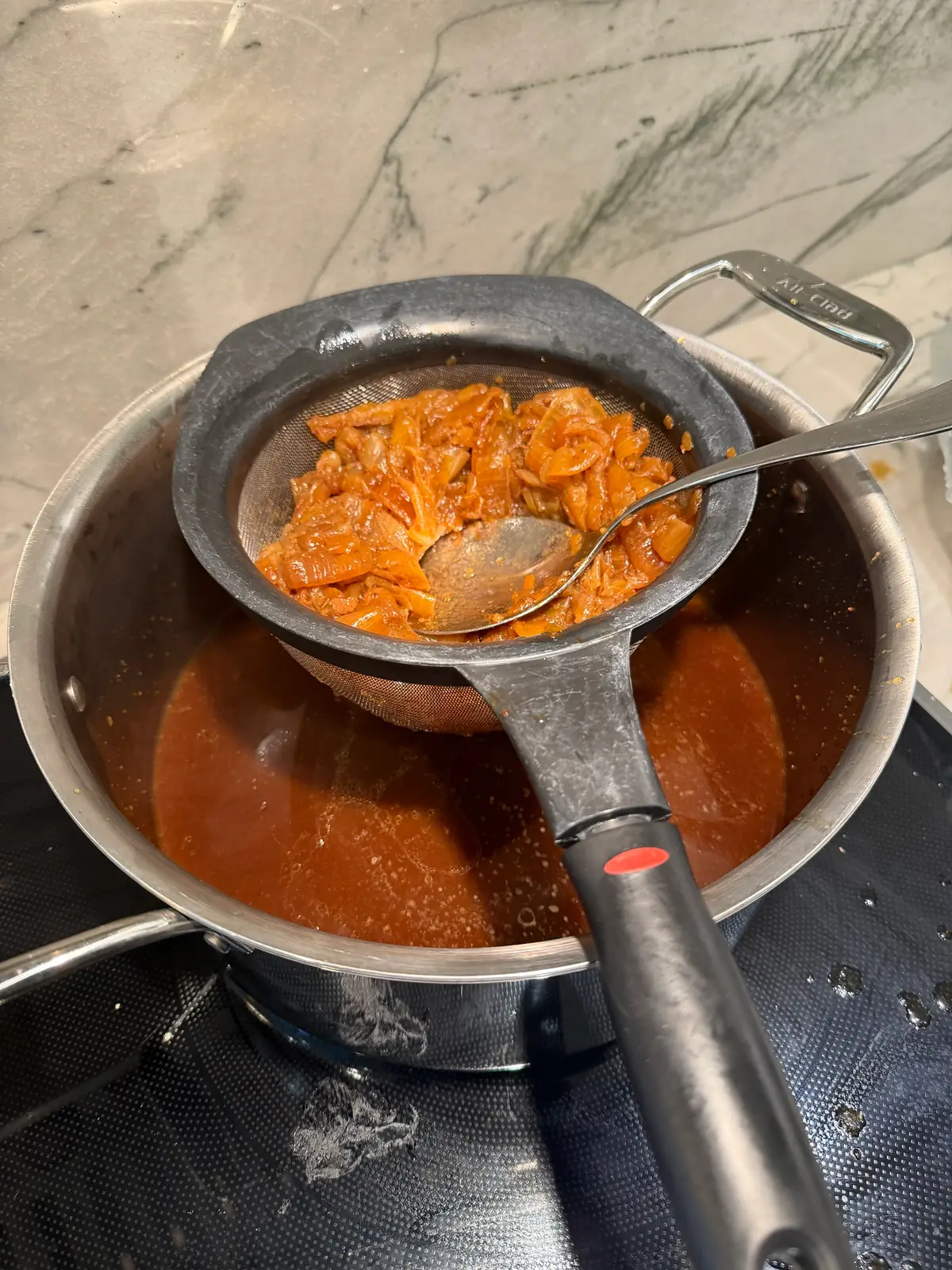 Step 11. The melted pan juices and onions strained through a sieve into a pot